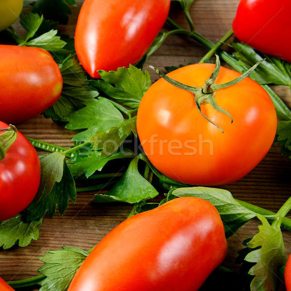 Tomatoes and celery on wooden background. Stock photo © alinamd