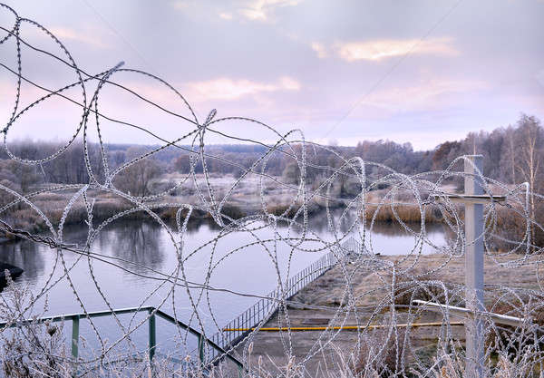 Post a fence of barbed wire in winter in frost at dawn Stock photo © AlisLuch