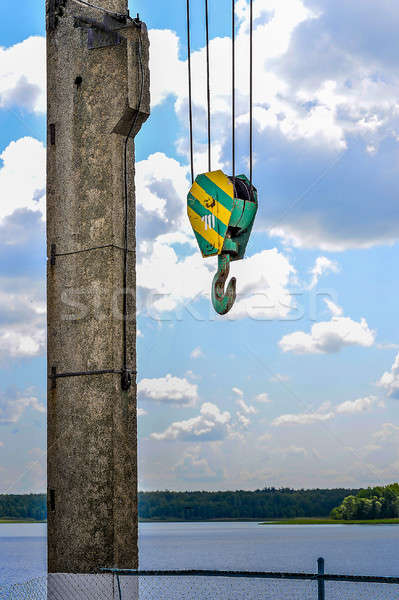Yellow-green hook of a construction crane on a rope on a background of clouds Stock photo © AlisLuch