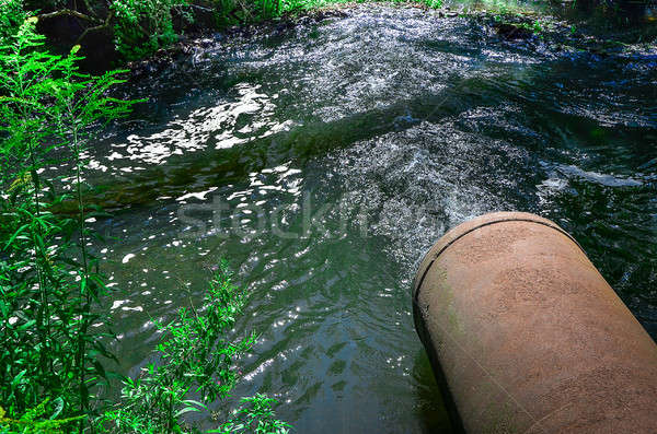 Water flows from the pipe into the river. Stock photo © AlisLuch
