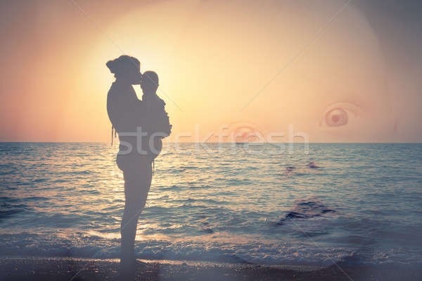 Silhouette of mother and child on the beach, and a child's face Stock photo © All32