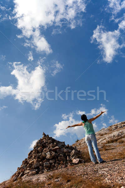 Girl with hands up near the pile of stones Stock photo © All32