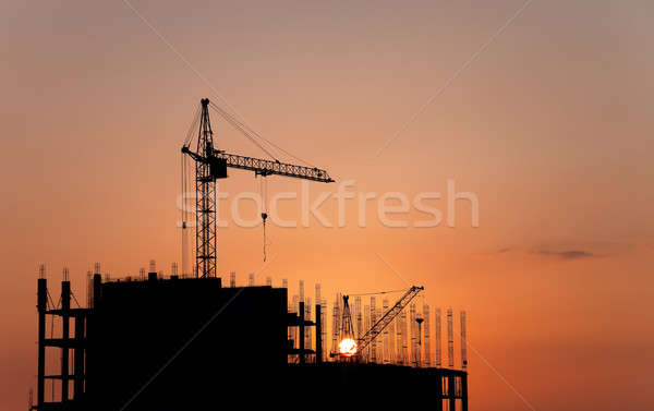 Construction cranes and concrete structure at sunset  Stock photo © All32