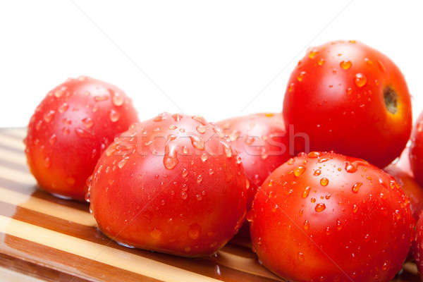 Red ripe tomatoes on a wooden board with water drops Stock photo © All32