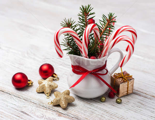 Jug with christmas candy canes on a wooden table Stock photo © almaje