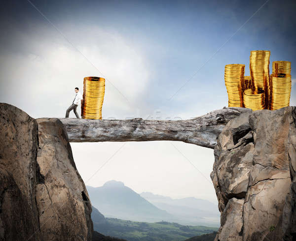 Businessman moves a pile of coins to a moneybox. concept of difficulty to saving money Stock photo © alphaspirit