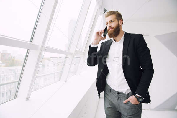 Businessman talking to the phone in office Stock photo © alphaspirit