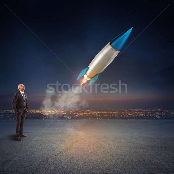 Businessman looks start a missile. Concept of company startup and new business. 3D Rendering. Stock photo © alphaspirit