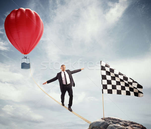 Business concept of businessman who overcome the problems reaching the flag on a rope Stock photo © alphaspirit