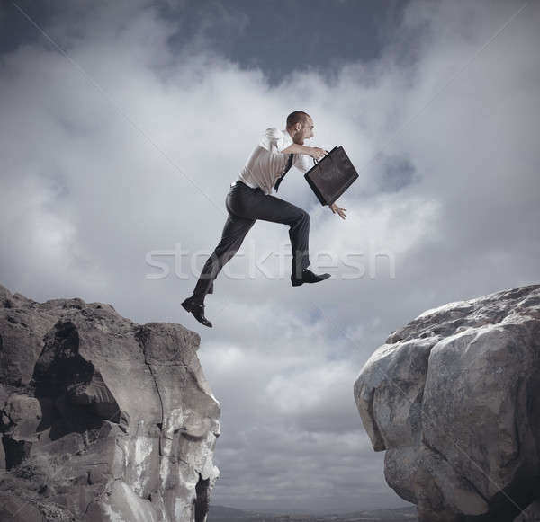 Businessman jumping over the mountains Stock photo © alphaspirit