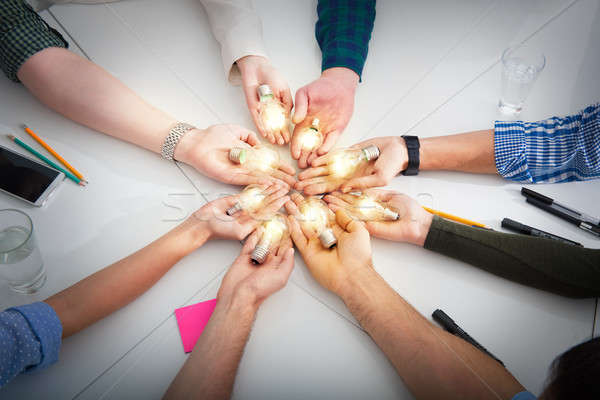 Stock photo: Teamwork and brainstorming concept with businessmen that share an idea with a lamp. Concept of start