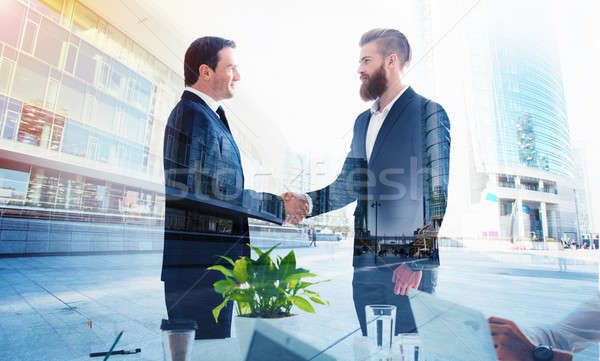 Handshaking business person in office. concept of teamwork and partnership. double exposure Stock photo © alphaspirit