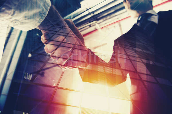 Stock photo: Handshaking business person in office. concept of teamwork and partnership. double exposure