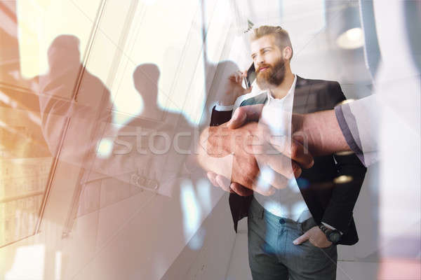 Handshaking business person in office. concept of teamwork and partnership. double exposure Stock photo © alphaspirit