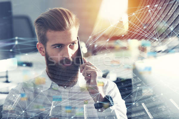 Businessman talking to the phone in office with internet network effects. double exposure Stock photo © alphaspirit