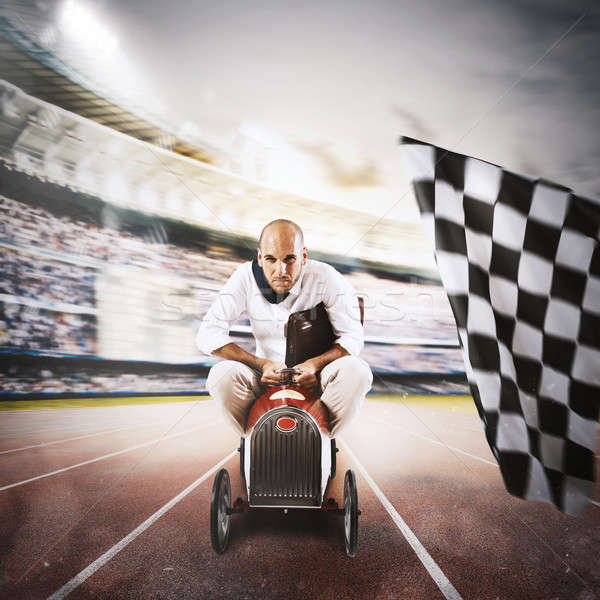 Stock photo: Successful businessman in a small car on the finishing line