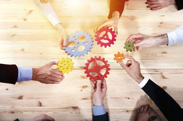 Business team connect pieces of gears. Teamwork, partnership and integration concept Stock photo © alphaspirit