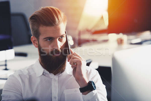 Businessman talking to the phone in office Stock photo © alphaspirit