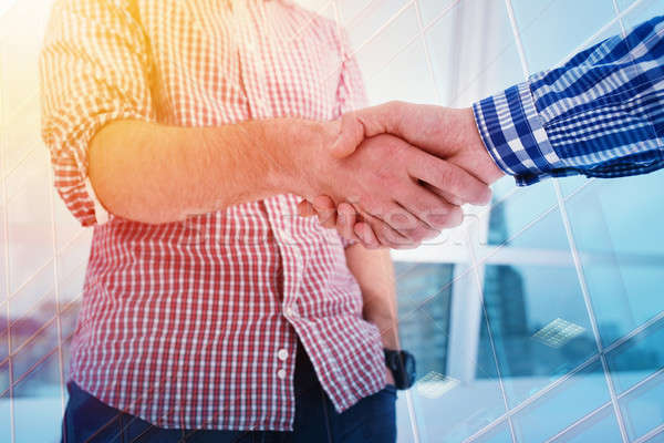 Handshaking business person in office. concept of teamwork and partnership. double exposure Stock photo © alphaspirit