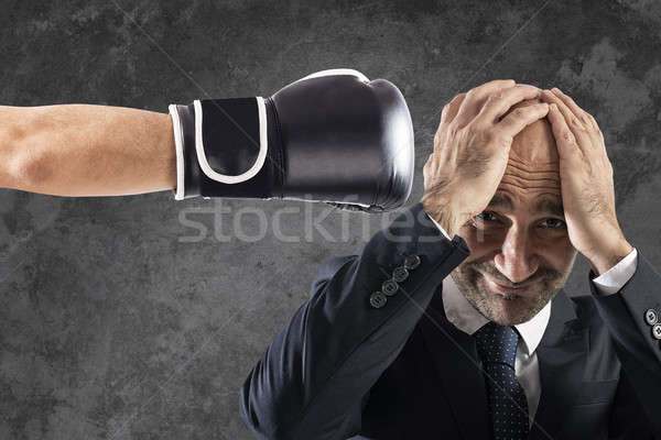 Stock photo: Businessman receives fists from competitors. concept of difficult career