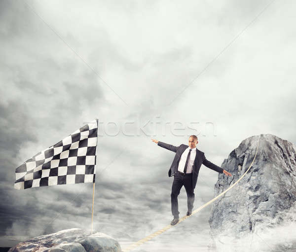 Business concept of businessman who overcome the problems reaching the flag on a rope Stock photo © alphaspirit