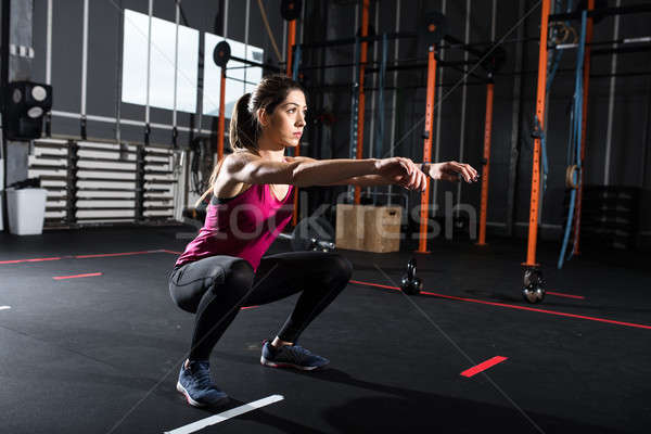 Athletic girl does squat exercises at the gym Stock photo © alphaspirit