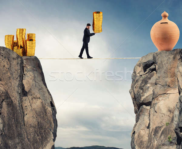 Businessman moves a pile of coins to a moneybox. concept of difficulty to saving money Stock photo © alphaspirit