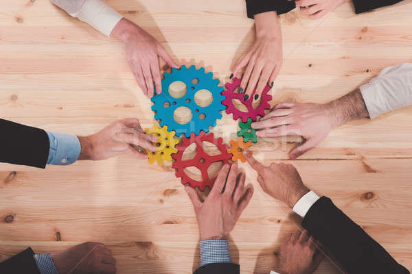 Business team connect pieces of gears. Teamwork, partnership and integration concept Stock photo © alphaspirit