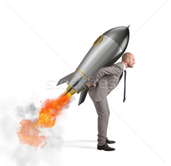Determination and power businessman that holds a rocket isolated on white background Stock photo © alphaspirit