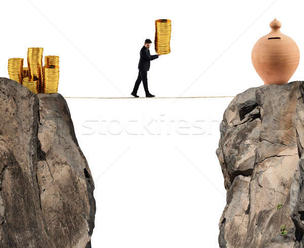 Businessman moves a pile of coins to a moneybox. concept of difficulty to saving money Stock photo © alphaspirit