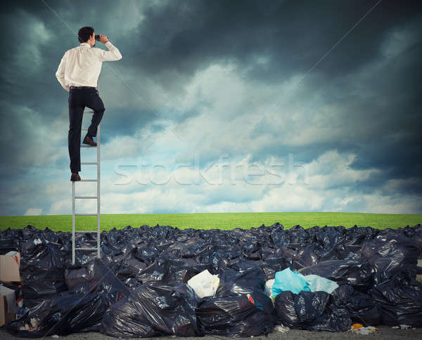 Businessman on a stairs searches far for clean environment. overcome the global pollution problem Stock photo © alphaspirit