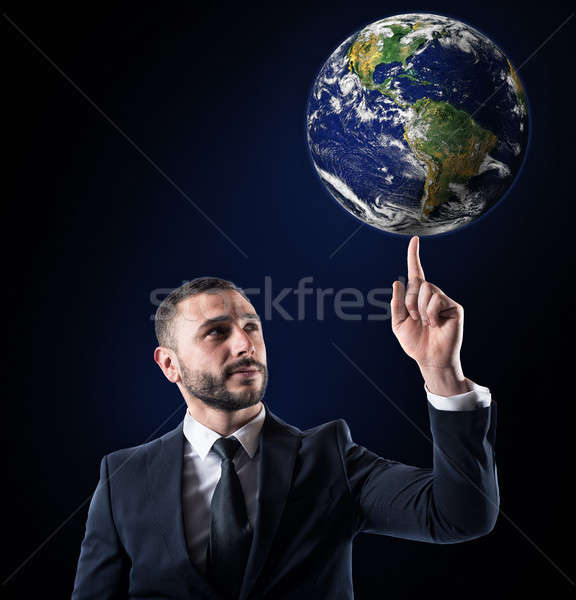 Businessman holds the world with a finger. World provided by NASA Stock photo © alphaspirit