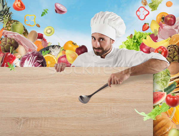 Chef with board and vegetables background Stock photo © alphaspirit