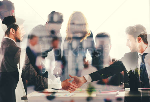 Handshaking business person in office. concept of teamwork and partnership. double exposure Stock photo © alphaspirit