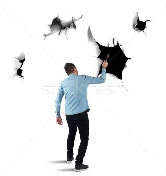 Stock photo: Man breaks a wall with a hammer