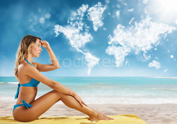 Girl in bikini sits on a beach looking for new travel destination. Stock photo © alphaspirit