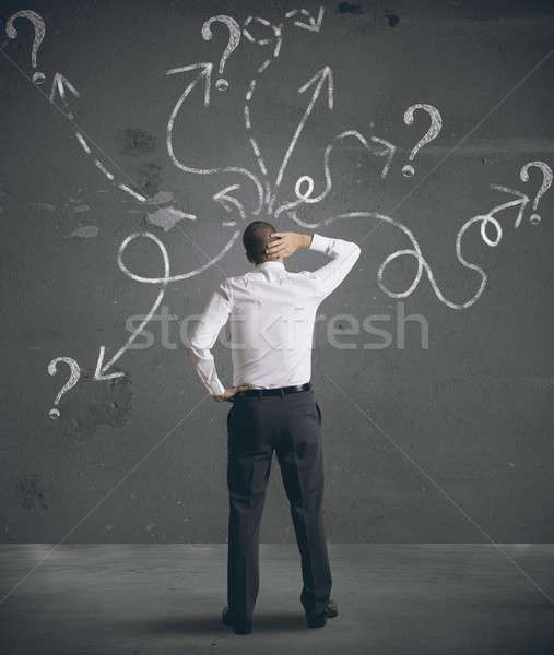 Businessman looking at arrows pointed in different directions Stock photo © alphaspirit