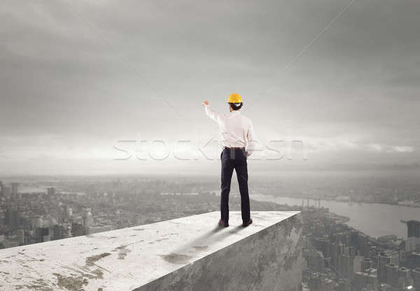 Businessman with helmet indicates the right direction Stock photo © alphaspirit