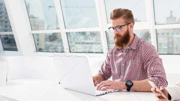 Hipster businessman at the office working with a laptop with his team Stock photo © alphaspirit