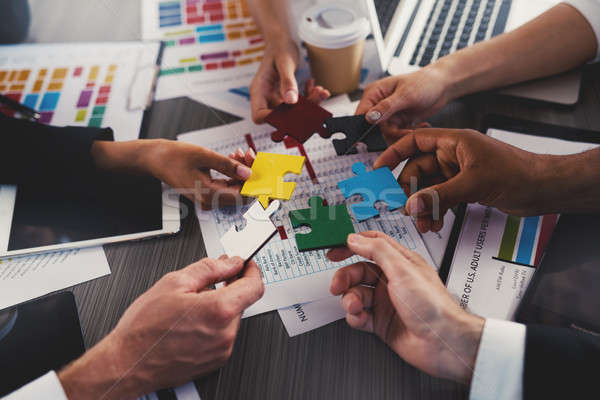 Businessmen building colored puzzles together. Concept of teamwork, partnership, integration and sta Stock photo © alphaspirit