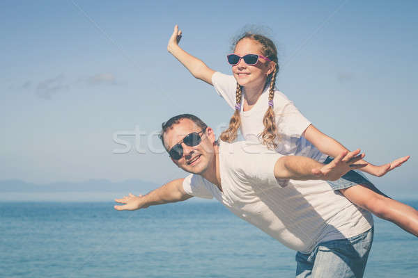 Father and daughter playing on the beach at the day time. Stock photo © altanaka