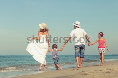 Happy family standing on the beach at the day time. Stock photo © altanaka