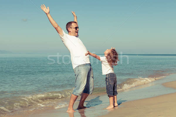 Father and son playing on the beach at the day time. Stock photo © altanaka