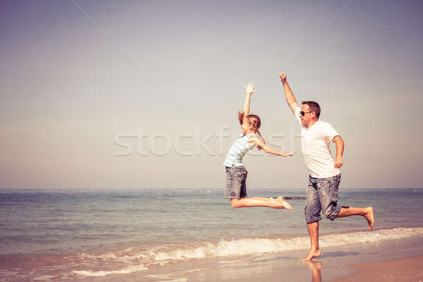 Father and daughter playing on the beach at the day time. Stock photo © altanaka