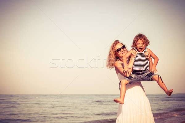 Mother and son playing on the beach at the day time. Stock photo © altanaka