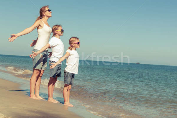 Mother and daughters  playing on the beach at the day time. Stock photo © altanaka