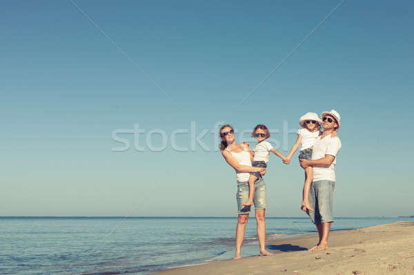 Happy family standing on the beach at the day time. Stock photo © altanaka