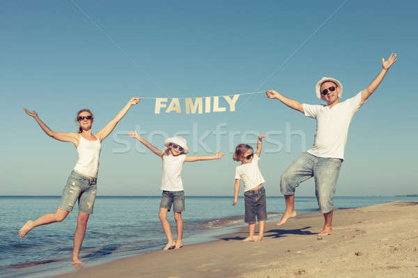 Happy family standing on the beach at the day time. Stock photo © altanaka