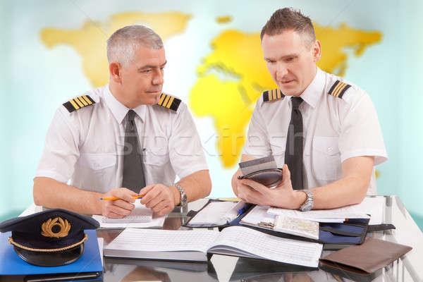 Airline pilots filling in papers in ARO Stock photo © Amaviael