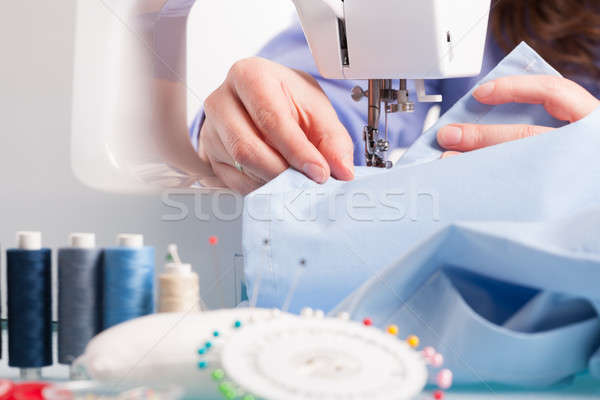 Hands on sewing machine with reels of colour threads and sewing  Stock photo © Amaviael